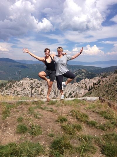 Student and their mother doing the tree pose on a mountain