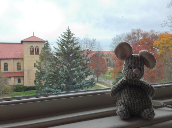 Mouse stuffed animal perched on a window sill