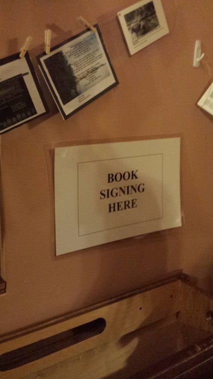 A sign that reads "book signing here"