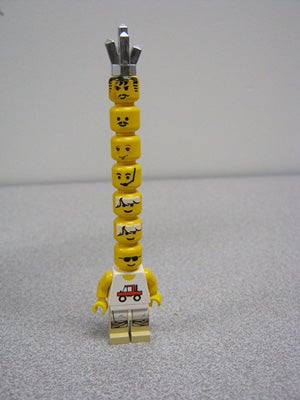 A lego person with many heads stacked 
