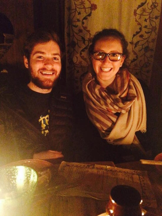 Two people smile at a dinner table