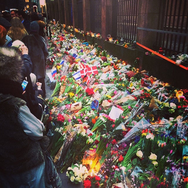 Hundreds of flowers laying outside of a synagogue
