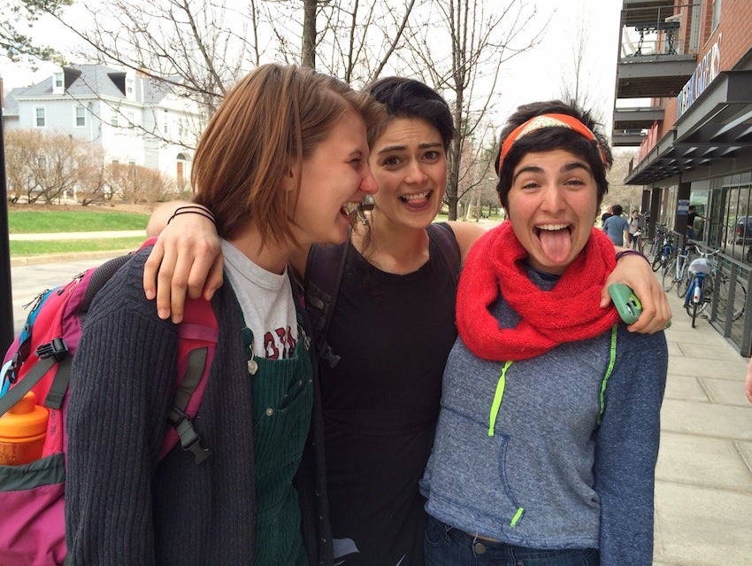 Georgia with her arms around two friends. Each are laughing and smiling for the photo