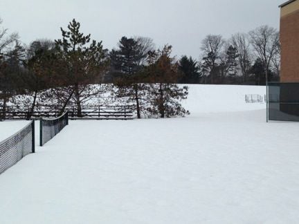 A snow-covered, gentle slope next to a building