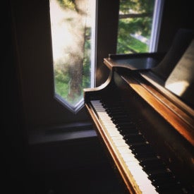 piano keyboard beside a sunny window
