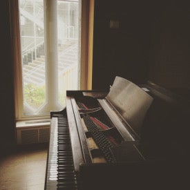 piano beside two tall windows