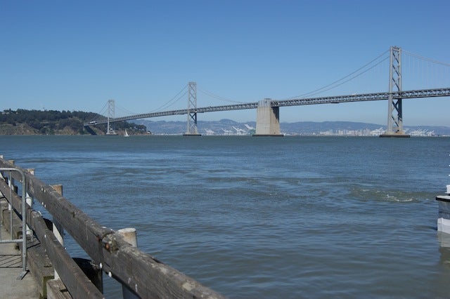 View of a gray bridge from a waterfront