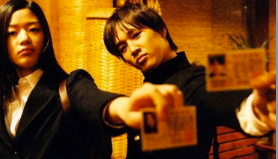 two people holding I.D.s for the camera