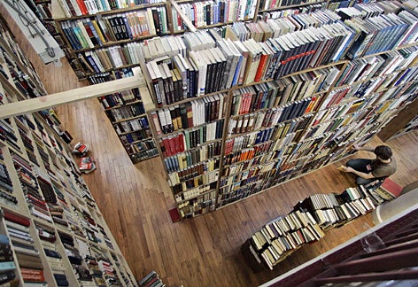 Viewed from above, many tall shelves are crammed full of books.