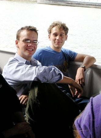 Two students smiling and posing for a photo on a boat