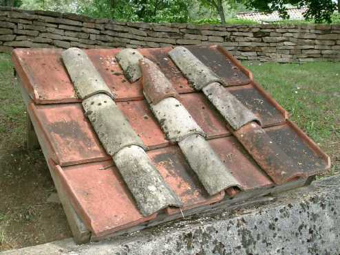 A square section of clay roof is displayed on the grass.