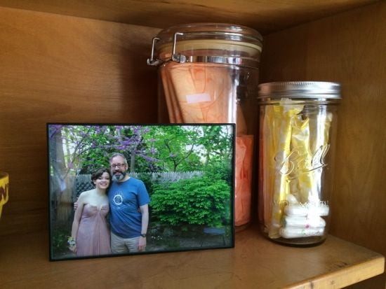 Shelf display includes a framed photo and two jars of feminine products.