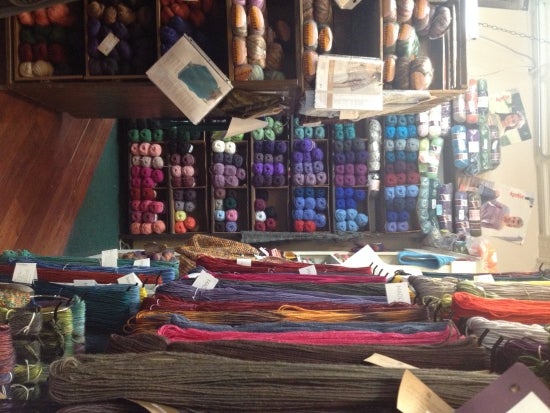 Many colors of yarn on a shelf
