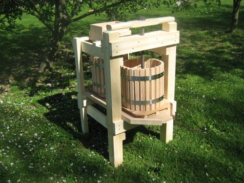A wooden cube-like contraption with a barrel at its center 