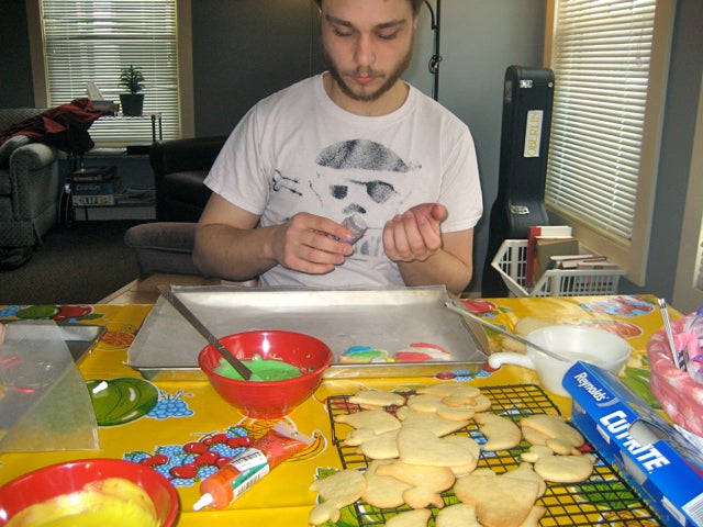 A student with cookies and cookie decorations at a table