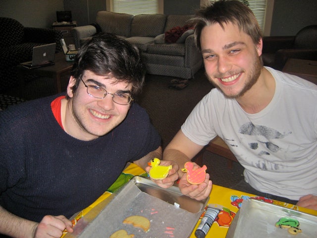 Two students pose with decorated duck shaped cookies