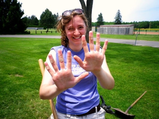 Someone posing for the photo holding up the palms of their hands with bandages on each finger
