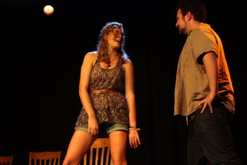 Two students on stage talking to each other