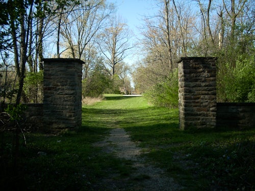 The entrance of a  large stone gate entering the arboretum