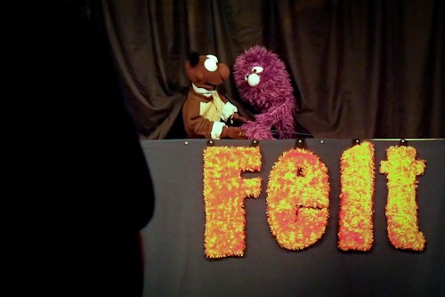 Puppets hold hands on stage 