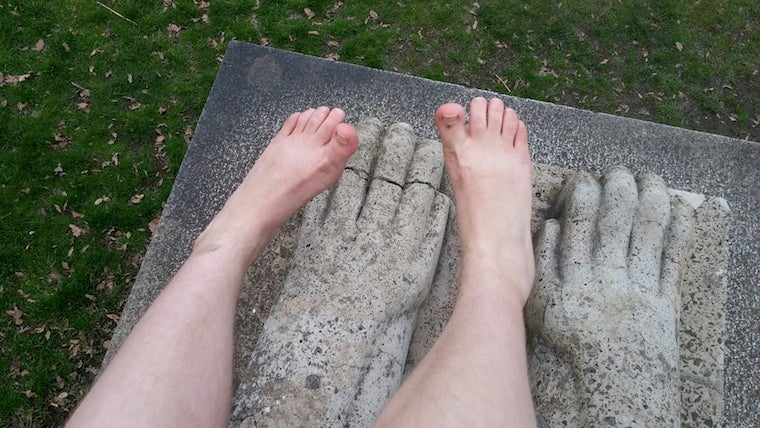 Photographers feet on top of statue griffen feet 