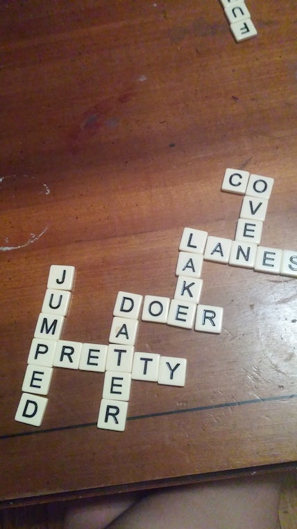 Letter tiles on a table form the words: jumped, pretty, dater, doer, lake, lanes, co, oven