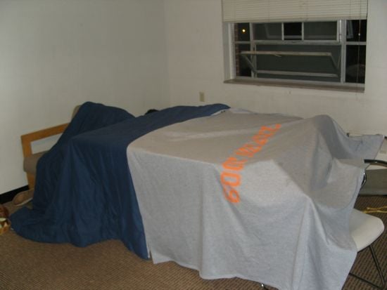 Blankets are arranged over chairs, making a hiding place.