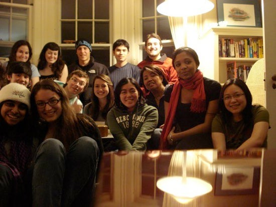 Group of students smiling for a picture in a living room