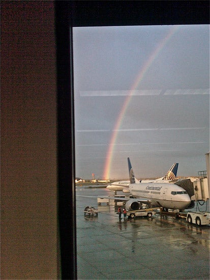 A rainbow over parked airplanes 