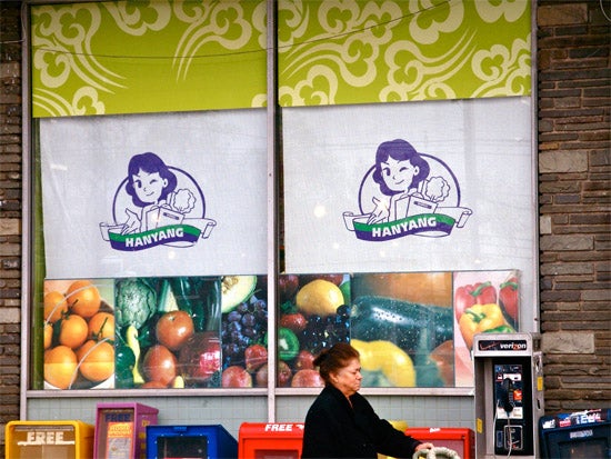 Woman wheeling a cart in front of a supermarket window 