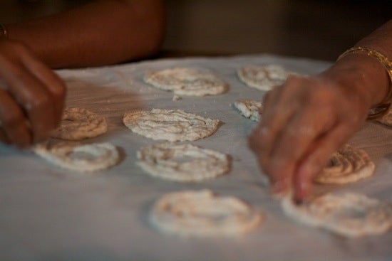 Hands assemble the dough shapes on a tray