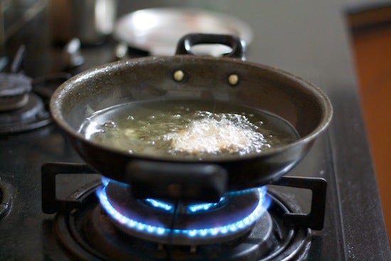 Frying dough in a pan of oil over the stove