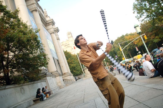 A student spins poi in front of a museum