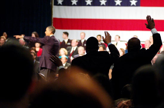 Crowd members wave at the president on stage