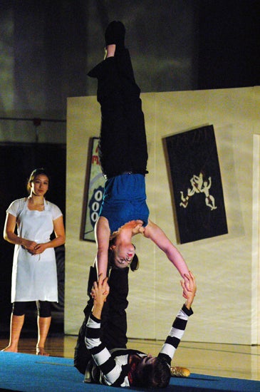 Performers balancing on one another
