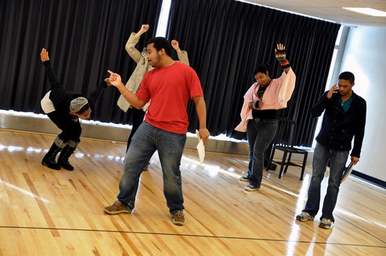 Five performers rehearse dance moves.