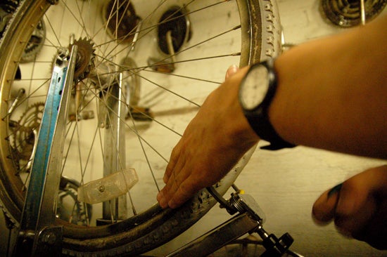 A student adjust the tire of a bike wheel 