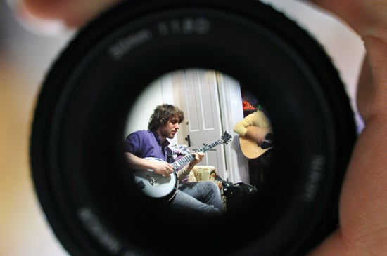 Student playing the banjo, seen through a lens