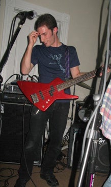Eric playing bass guitar, surrounded by amps and microphones.