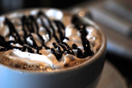 Close up of a mug with whipped cream and chocolate syrup 