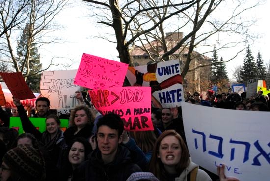 The crowd holds protest signs 