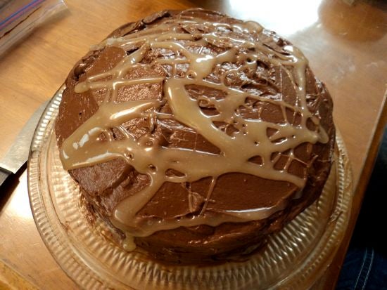 An iced cake with brown frosting 