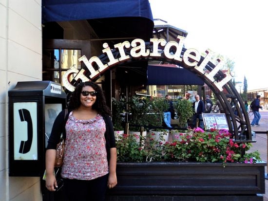 Someone posing for a photo in front of the Ghirardelli sign 