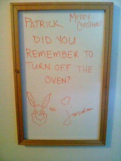 A white board message: "Patrick, did you remember to turn of the oven?"