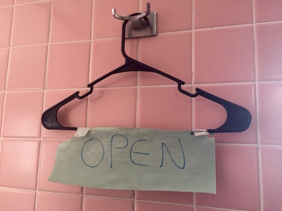 Hand-made sign on a hanger reads 'Open'