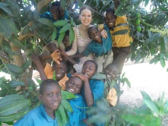 Oberlin student in a tree with a group of school students 
