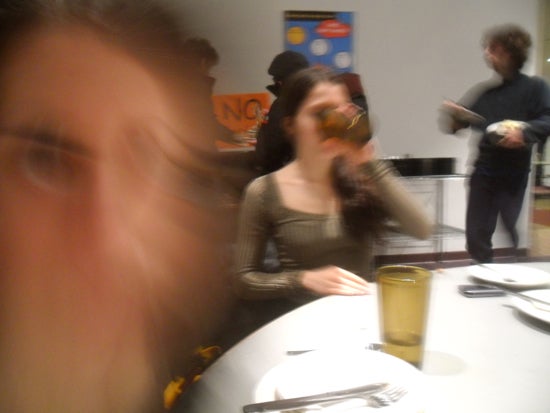 A blurry selfie featuring a girl drinking out of a cup
