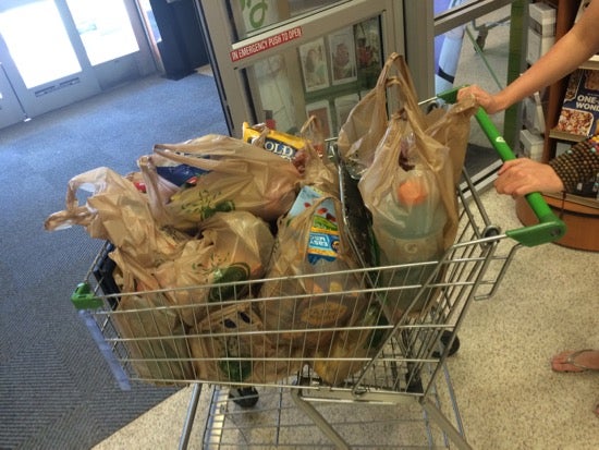 A grocery cart full of bagged groceries 