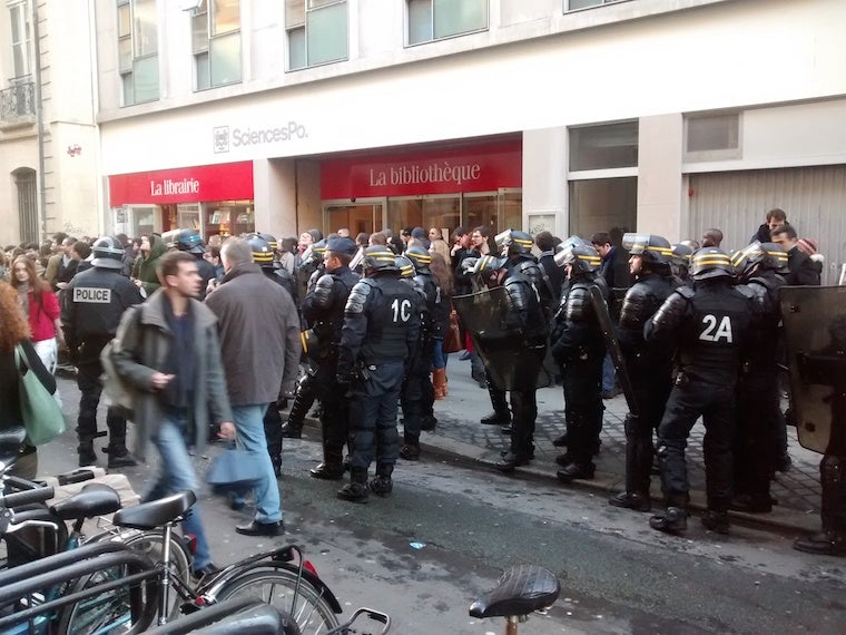 A crowd and police in front of the Sciences Po library 