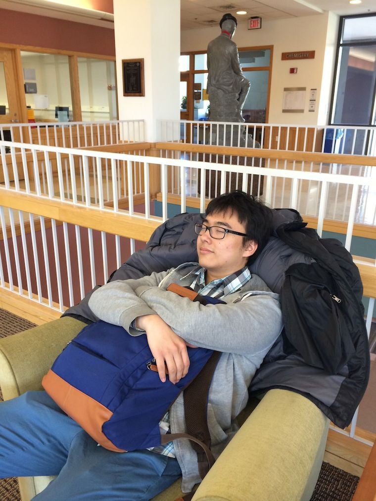Chul naps in a lounge chair clutching his backpack